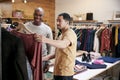 Two male friends looking at clothes in a clothes shop Royalty Free Stock Photo