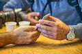 Two male friends looking at the screen of a mobile phone, detail on hands Royalty Free Stock Photo