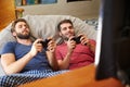 Two Male Friends In Pajamas Playing Video Game Together Royalty Free Stock Photo