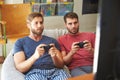 Two Male Friends In Pajamas Playing Video Game Together Royalty Free Stock Photo