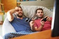 Two Male Friends In Pajamas Playing Video Game Together Royalty Free Stock Photo