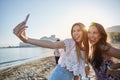 Two male friends taking selfie on beach pulling faces Royalty Free Stock Photo