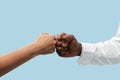 Two male hands competion in arm wrestling isolated on blue studio background