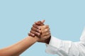 Two male hands competion in arm wrestling isolated on blue studio background