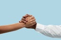 Two male hands competion in arm wrestling isolated on blue studio background