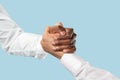 Two male hands competion in arm wrestling isolated on blue studio background