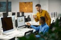 Two male managers works on computer in IT office