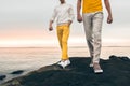 Two male models wearing fashionable spring summer outfit with colorful pants, t-shirt, sweater and shoes walking outdoors Royalty Free Stock Photo
