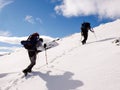 Two male mountain climbers with heavy backpacks on the way to the summit on a winter day Royalty Free Stock Photo