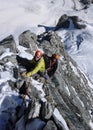 Two male mountain climbers on a steep rock and snow ridge in the Swiss Alps Royalty Free Stock Photo