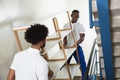 Two Male Movers Carrying The Empty Shelf At Home Royalty Free Stock Photo