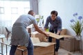 Two Male Movers Carrying a furniture and assmble it Royalty Free Stock Photo