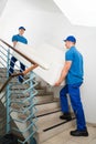 Two Male Movers Carrying Sofa On Staircase Royalty Free Stock Photo