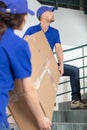 two male movers walking with box on staircase Royalty Free Stock Photo
