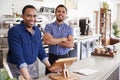 Two male owners behind the counter at their coffee shop