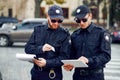 Two male police officers inspect car parking Royalty Free Stock Photo