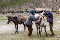 Two male porters loading a heavy sack on a pack mule Royalty Free Stock Photo