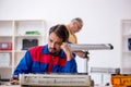 Two male repairmen repairing air-conditioner