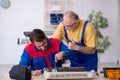 Two male repairmen repairing air-conditioner