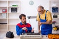 Two male repairmen repairing air-conditioner