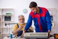 Two male repairmen repairing air-conditioner