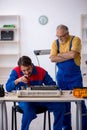 Two male repairmen repairing air-conditioner