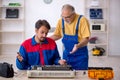 Two male repairmen repairing air-conditioner Royalty Free Stock Photo