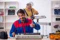 Two male repairmen repairing air-conditioner