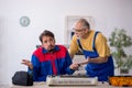 Two male repairmen repairing air-conditioner