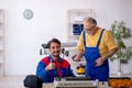 Two male repairmen repairing air-conditioner