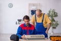 Two male repairmen repairing air-conditioner