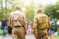 Two male security guards on public event among blurred background of many people on sunny street