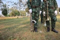 Two male soldiers stand holding an instrument Saxophone and trombone Lawn background