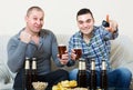 Two male sport fans watching game at home Royalty Free Stock Photo