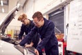 Two Male Students Studying For Auto Mechanic Apprenticeship At College Working On Car Engine Royalty Free Stock Photo