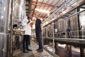Two male technicians working at a wine factory, low angle