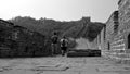 Two male tourists walking through the great wall. Mutianyu section, Beijing, China. View from the ground. Black and white Royalty Free Stock Photo