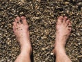 Two male white feet sunbathed on the sand of the beach Royalty Free Stock Photo