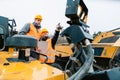 Two male workers on excavator in digging operation or quarry