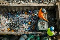 Two male workers are sorting through a dumpster filled with plastic bottles, Organizing recyclables and separating them from Royalty Free Stock Photo