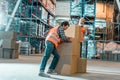 two male workers in vests moving boxes