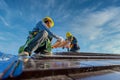 Two male workers wearing safety clothes Installing the roof tile house That is a ceramic tile roof On the construction site Royalty Free Stock Photo