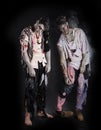 Two male zombies standing on black background, full length