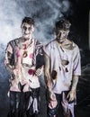 Two male zombies standing on black smoky background Royalty Free Stock Photo