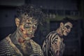 Two male zombies standing outdoor at night for Halloween