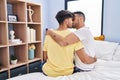 Two man couple hugging each other and kissing sitting on bed at bedroom Royalty Free Stock Photo