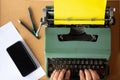 Two man hand typing on Vintage old mint green Thai typewriter with plain yellow paper Royalty Free Stock Photo