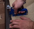 Two man hands using stapler upholstering paricle board with leatherette Royalty Free Stock Photo