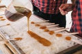 Two man pouring maple syrup on ice