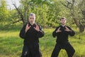 Two man practice tai Chi in a blooming apple garden Royalty Free Stock Photo